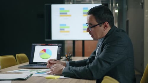 Closeup View of Caucasian Man Holding Documents with Financial Analysis