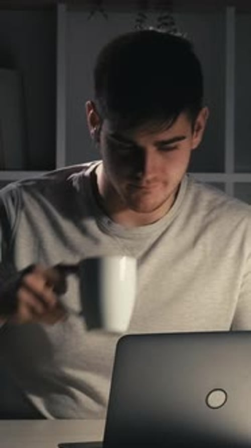 Young Adult Works Late Night on Laptop