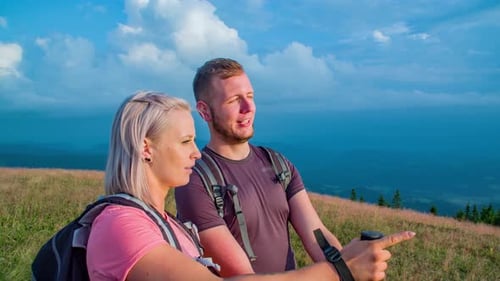 A slow motion shot of a man and woman discussing and point a direction then walk away.