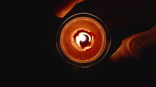 Close-Up Of A Red Candle. I hold and tilt a round candle.
