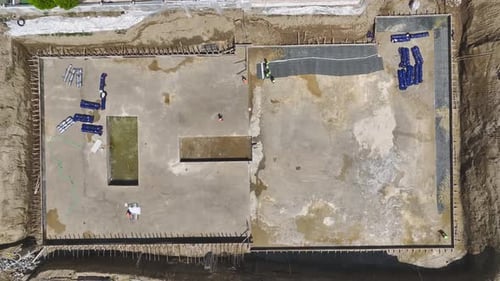 Vue aérienne des débuts de la fondation : coulage du béton et assemblage du coffrage