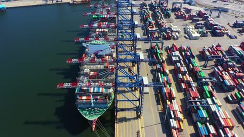 Container ship in export and import business and logistics. Shipping cargo to harbor by crane. Water