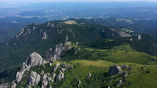 Flying Above Vibrant Green Rocky Mountains and Cliffs, Aerial View