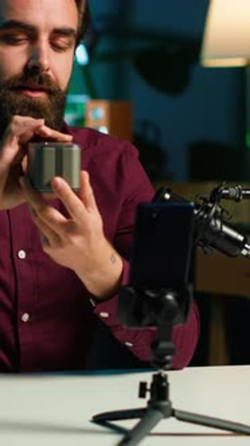 Man Reviews Speaker with Mobile Phone