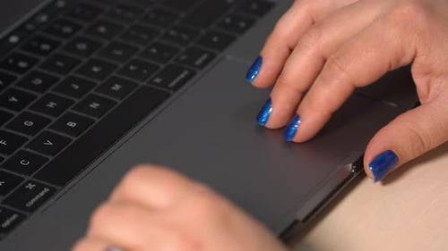 Hands Using Trackpad on Grey Laptop Computer