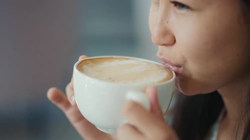 Young Adult Asian Woman Drinking Coffee