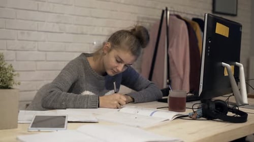 Teen Girl Studying and Writing at Her Desk