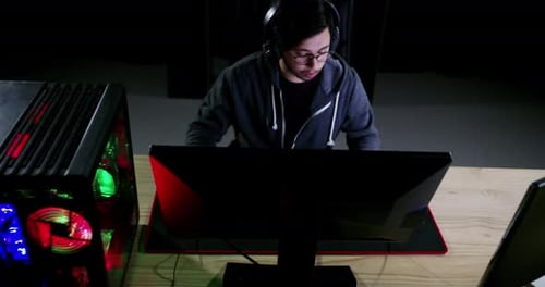 Young Adult Typing on Illuminated Computer Keyboard