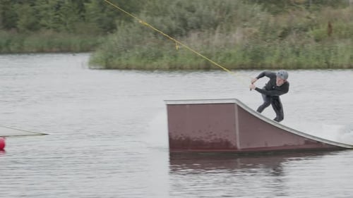 Wakeboarder Making Back Roll off Slider at Cable Park