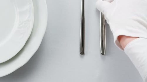 Un décor de table impeccable avec des gants blancs et une expérience culinaire sophistiquée