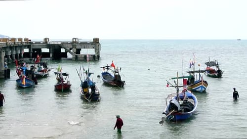 Fishermen walking to their fishing boats moored on the island shore