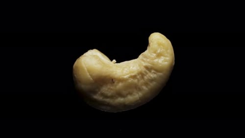 cashew nuts rotate, on a black background close-up. In move