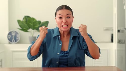 Woman Celebrating Success at Indoor Table