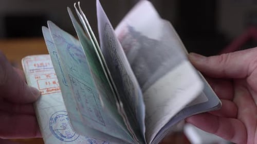 Hands Flipping Through Passport Pages