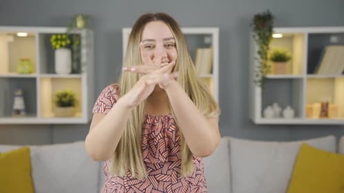 Smiling Young Adult Gesturing Playfully in Home Setting