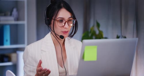 Woman Video Calling on Laptop Wearing Headset