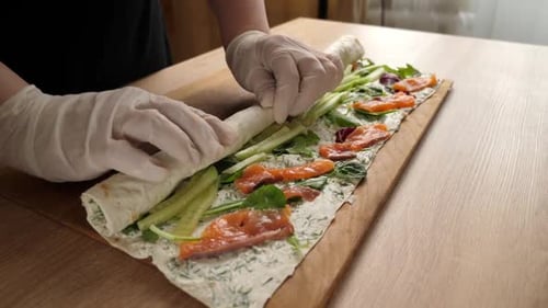 22. We wrap pita bread, forming a roll. Preparation of a roll with cheese, fish and vegetables