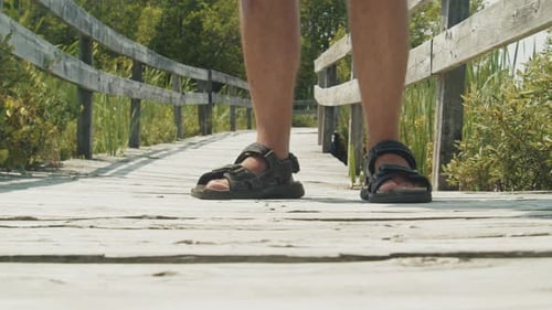 Man Uses Mosquito Repellent By the Lake on a Clear Day