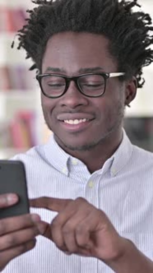 Young Man Using Smartphone Indoors in Vertical Video