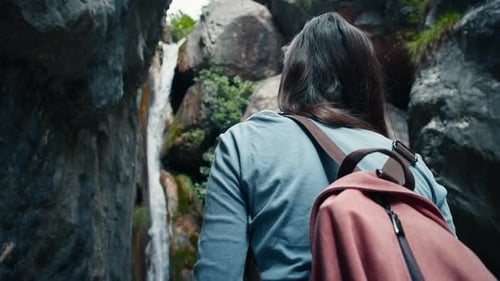 Backpacker Female Tourist Enjoy Waterfall View on Hiking Adventure Trip