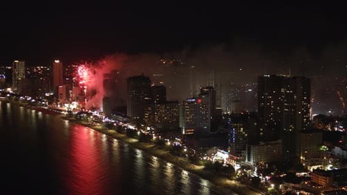Night city life, lighting and salute drone view. Firework in nighttime metropolis, aerial footage.