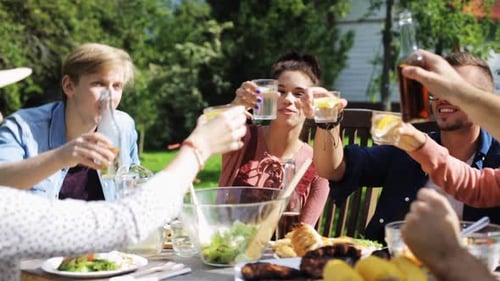 Leisure, Holidays, Eating, People And Food Concept - Happy Friends Having Dinner At Summer Garden...