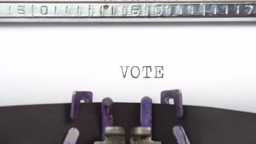 Vote word close up being typing and centered on a sheet of paper on old vintage typewriter mech