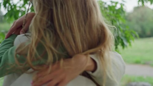 Affectionate Child and Adult Embracing Under Tree