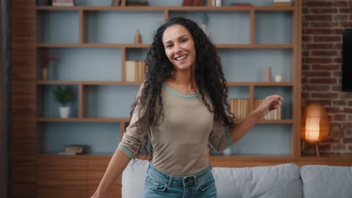 Young Woman Dances Smiling in Living Room
