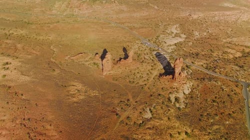 Few lonely little rocks among the deserted landscape. Highway crossing the scenery