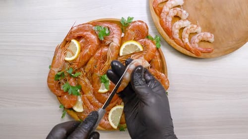Preparing Orange Shrimp with Knife and Black Gloves