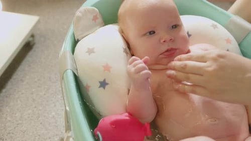 Loving Parent Gently Washing Adorable Baby
