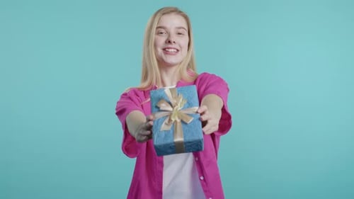 Young Woman Offers Birthday Gift with Joyful Smile