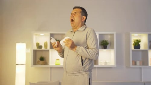 Homme se couvrant la bouche et le nez en éternuant.