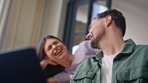 Smiling Young Adults Resting Indoors With Laptop