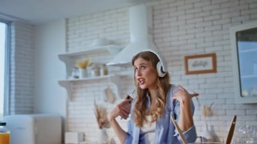 Woman Dancing and Singing in a Sunlit Kitchen