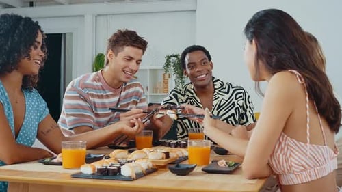 Group of friends eating sushi together at home.