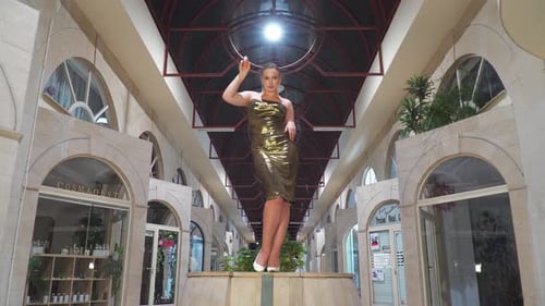 Woman in Gold Dress Posing with Perfume