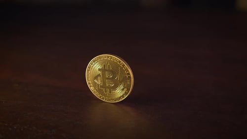 Une pièce d'or tourne sur une magnifique surface en bois reflétant son aspect brillant