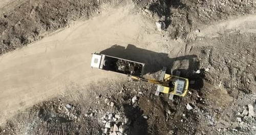 Industrielle Minenbagger graben den Boden auf der Baustelle und verladen Lastwagen