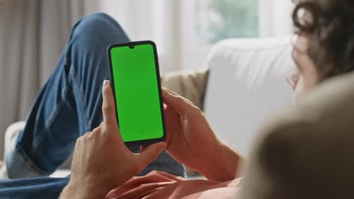User Scrolling Chroma Key Smartphone at Sofa Closeup Man Hands Holding Device