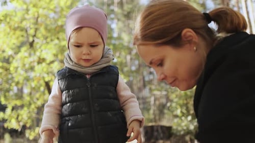 Mother and Child Walking Together in Forest