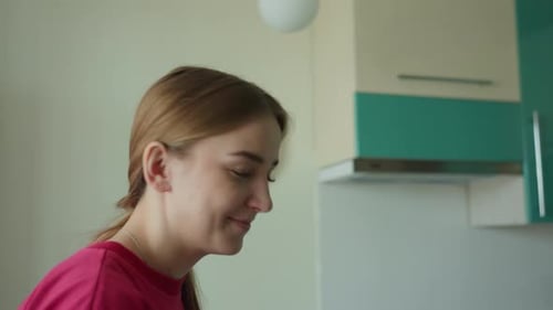 Smiling Young Woman Close Up in Kitchen