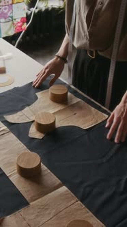 Tailor Placing Weights on Paper Pattern on Fabric