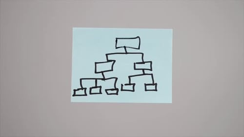 Hand Puts Diagram Sticky Note on Gray Surface