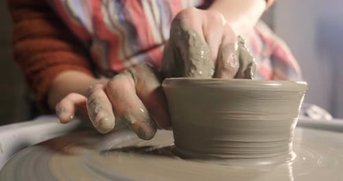 Hands Shaping Clay on Pottery Wheel Close Up