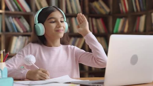 Happy Indian Latin Preteen Girl School Pupil Wearing Headphones Raising Hand Distance
