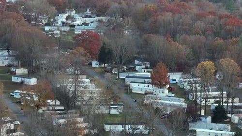 Aerial view of mobile trailer homes in american suburb district with colors trees in late autumn