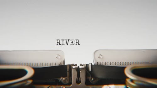 Old mechanical typewriter typing River Burst in a close-up view.
