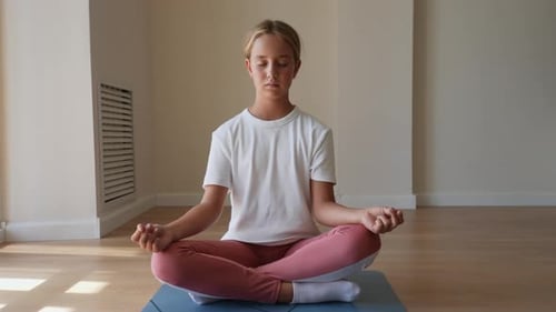 Girl Meditating Cross-legged on Yoga Mat